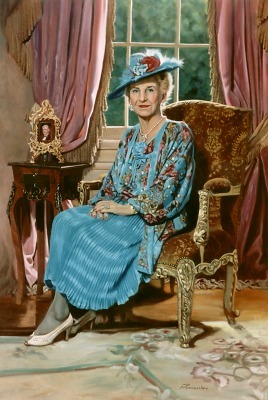Elderly woman sitting in an ornate armchair, wearing a large hat with a flower, in a room with pink curtains and a window.
