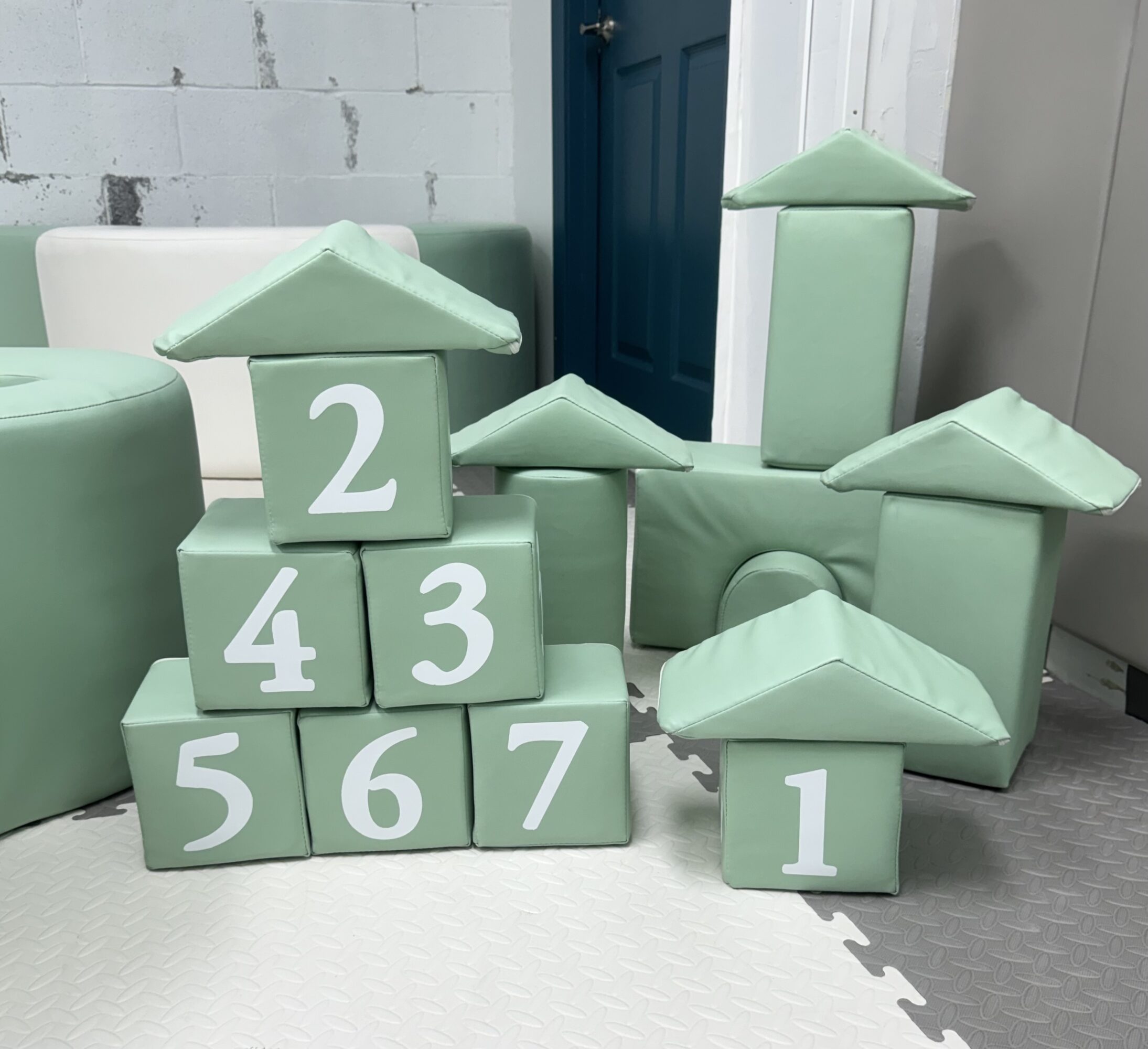 Stacked pastel green blocks with white numbers, arranged in a pyramid shape, with additional blocks nearby.