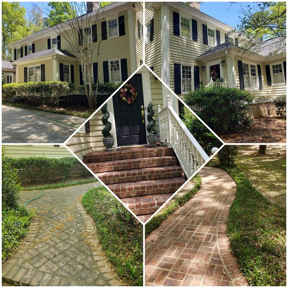 Three brick pathways leading to a yellow house with black shutters, surrounded by greenery and trees.