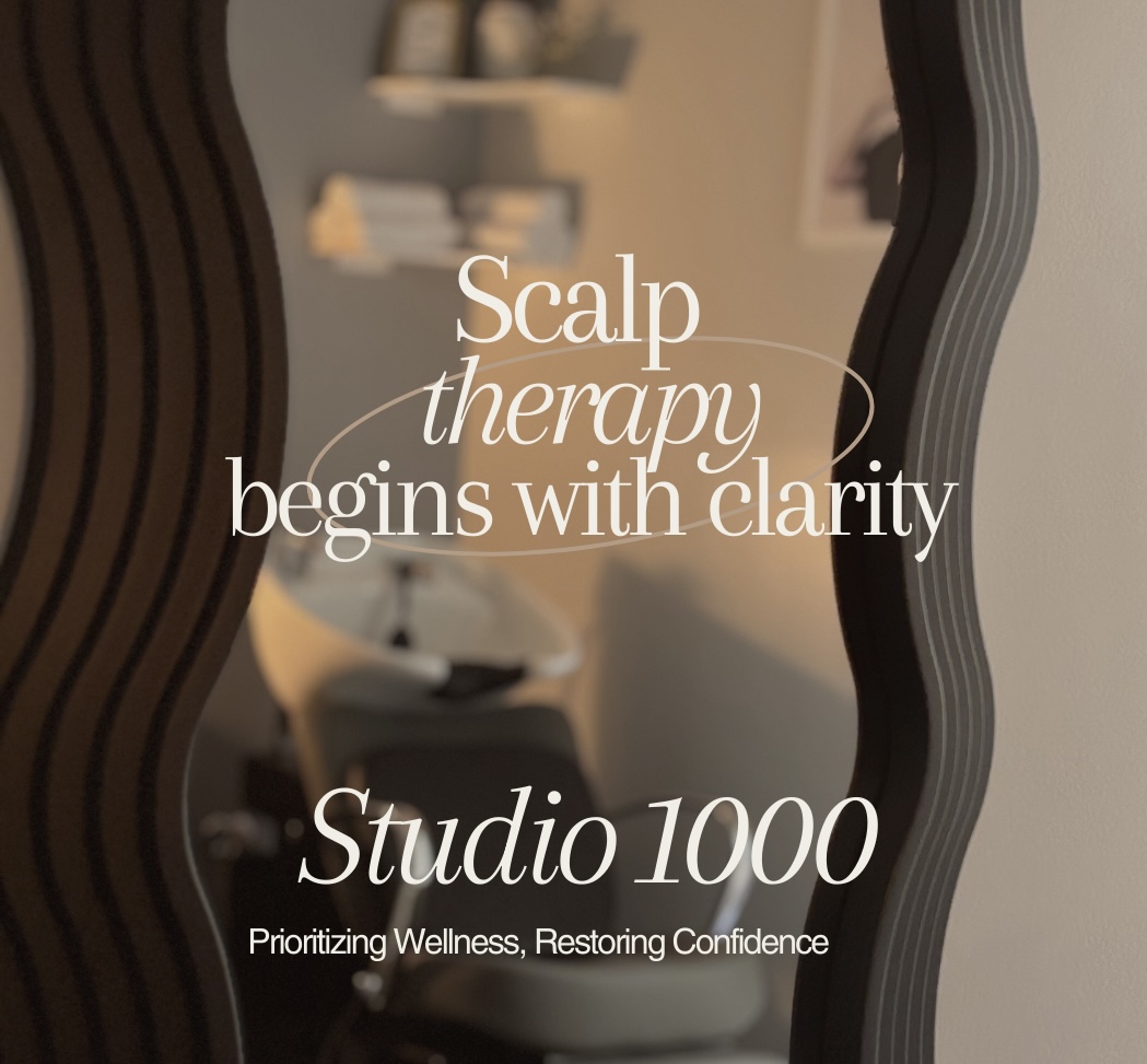 Decorative mirror with text about scalp therapy and Studio 100, in a room with shelves and a chair.