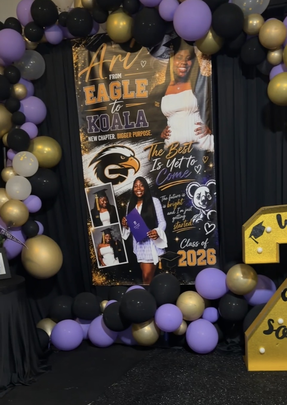 School graduation display with balloons, a poster of a student, and a yellow sign, celebrating the class of 2026.