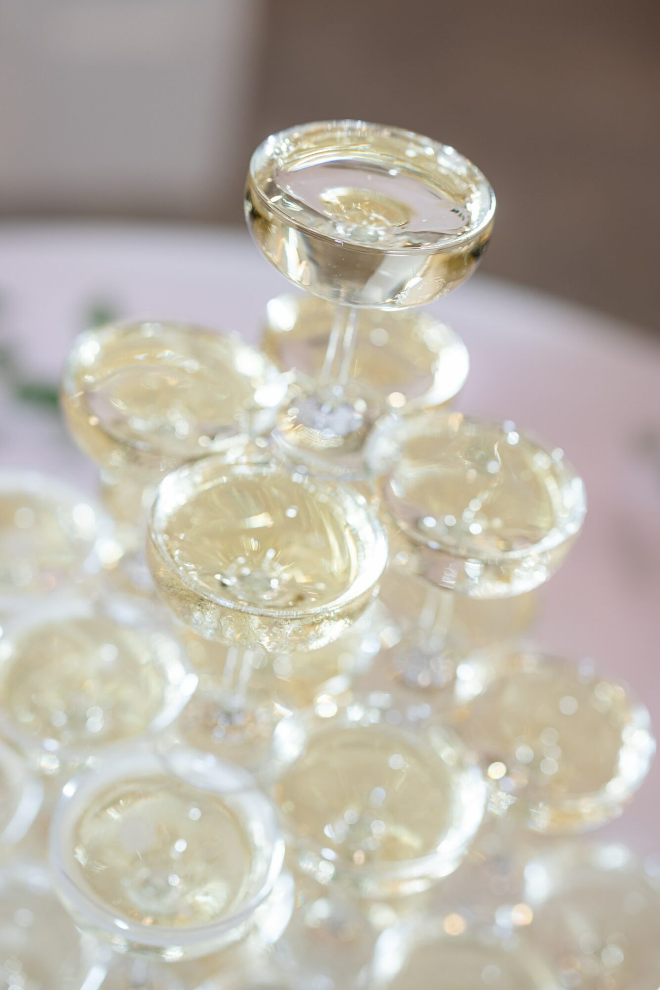 Close-up of glass jars stacked in a pyramid, with one jar at the top, filled with a clear substance.