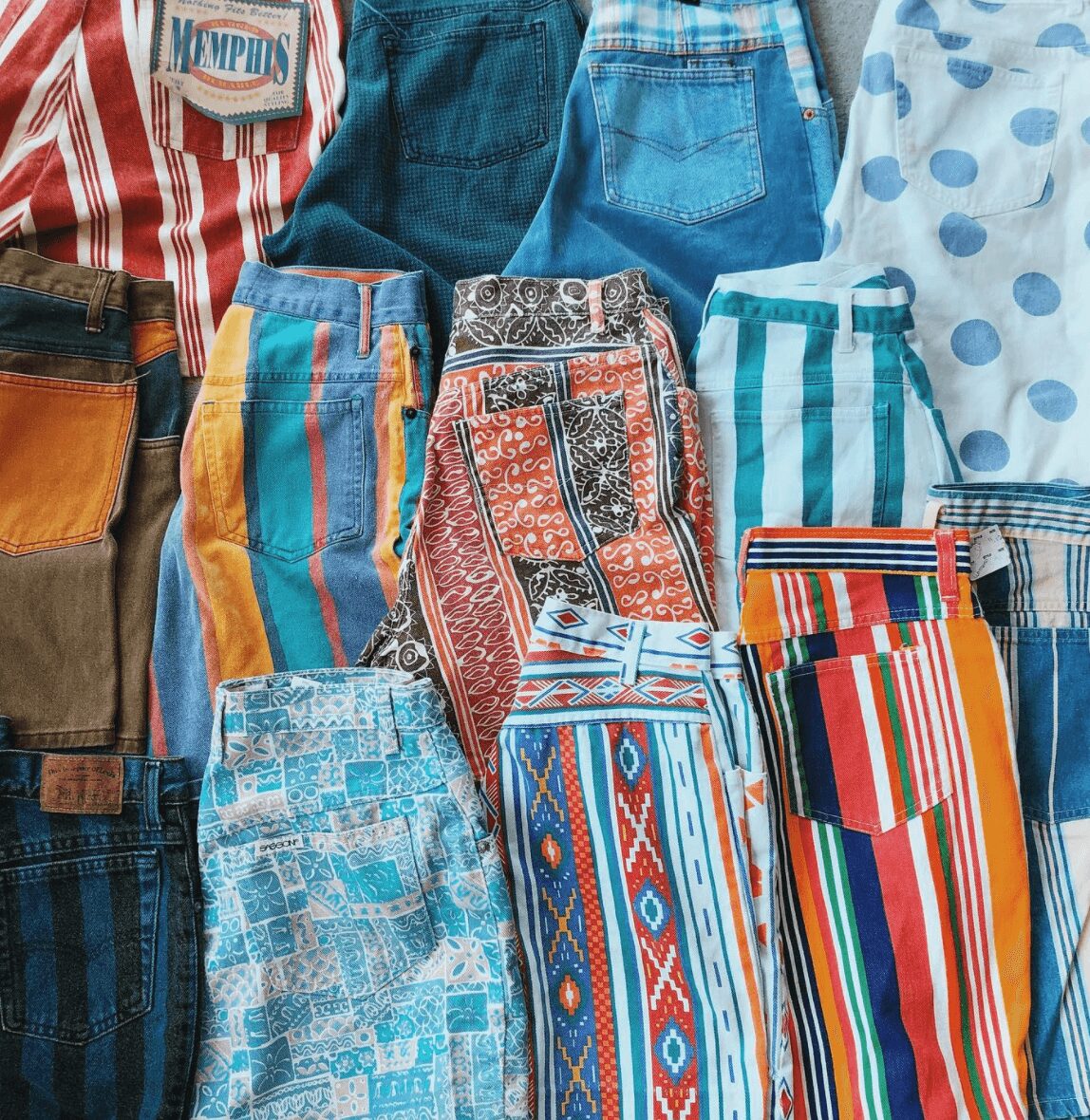 Collection of colorful shorts and pants with various patterns and colors, displayed together.