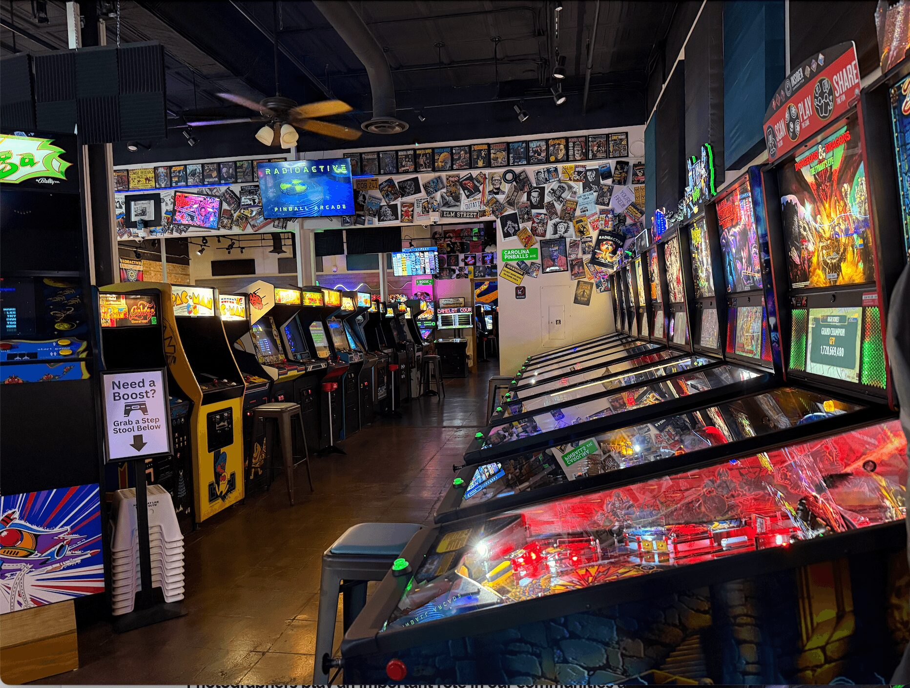 Arcade with pinball machines and video game machines, colorful screens, and a wall decorated with photos.