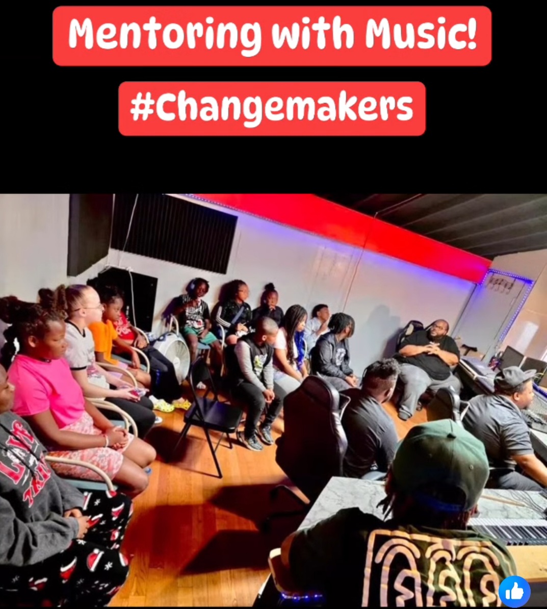 Group of children and adults in a room, participating in a music mentoring session, with a red and black background and text overlay.