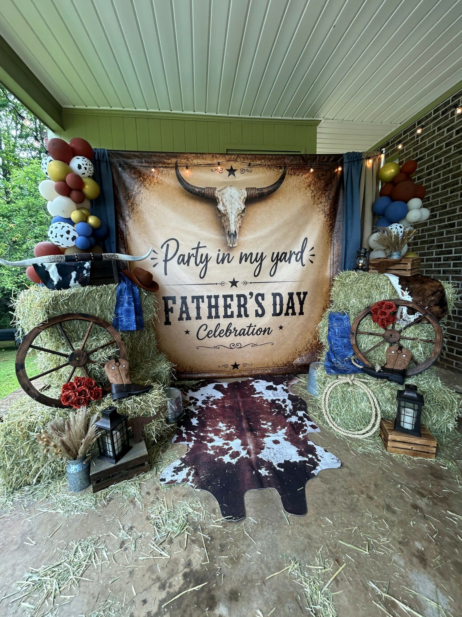 Cowhide rug, decorative items, and a banner with a message about a father's day celebration, in a rustic setting.