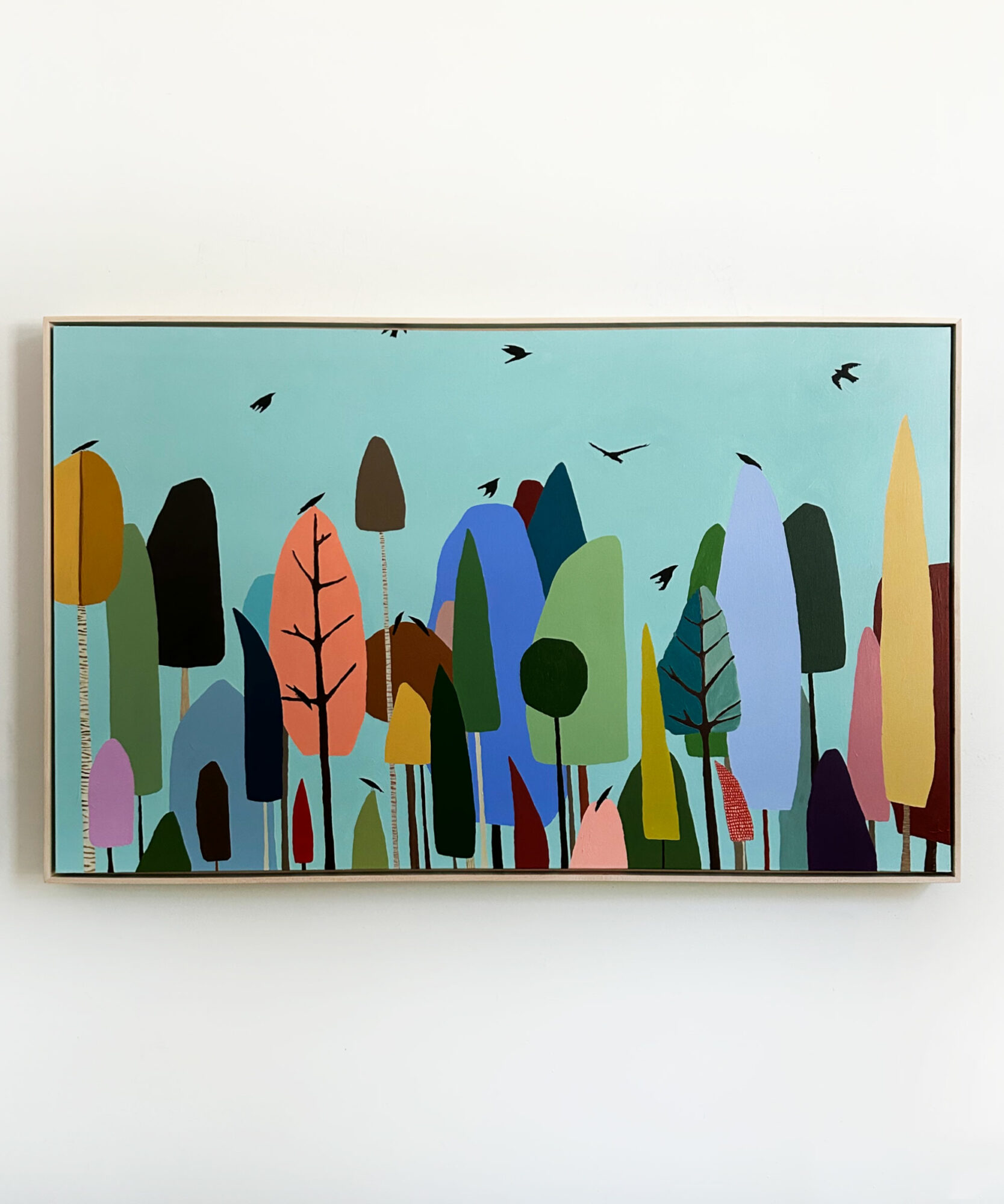 Colorful abstract trees and birds on a light blue background, in a framed artwork.