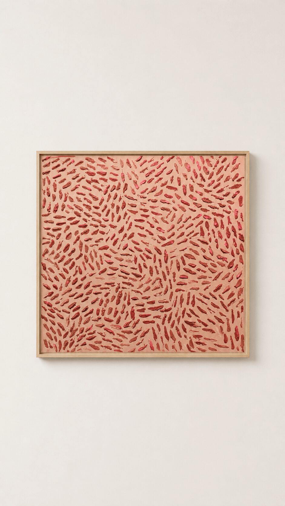 Square artwork with red and pink abstract pattern on a white wall.