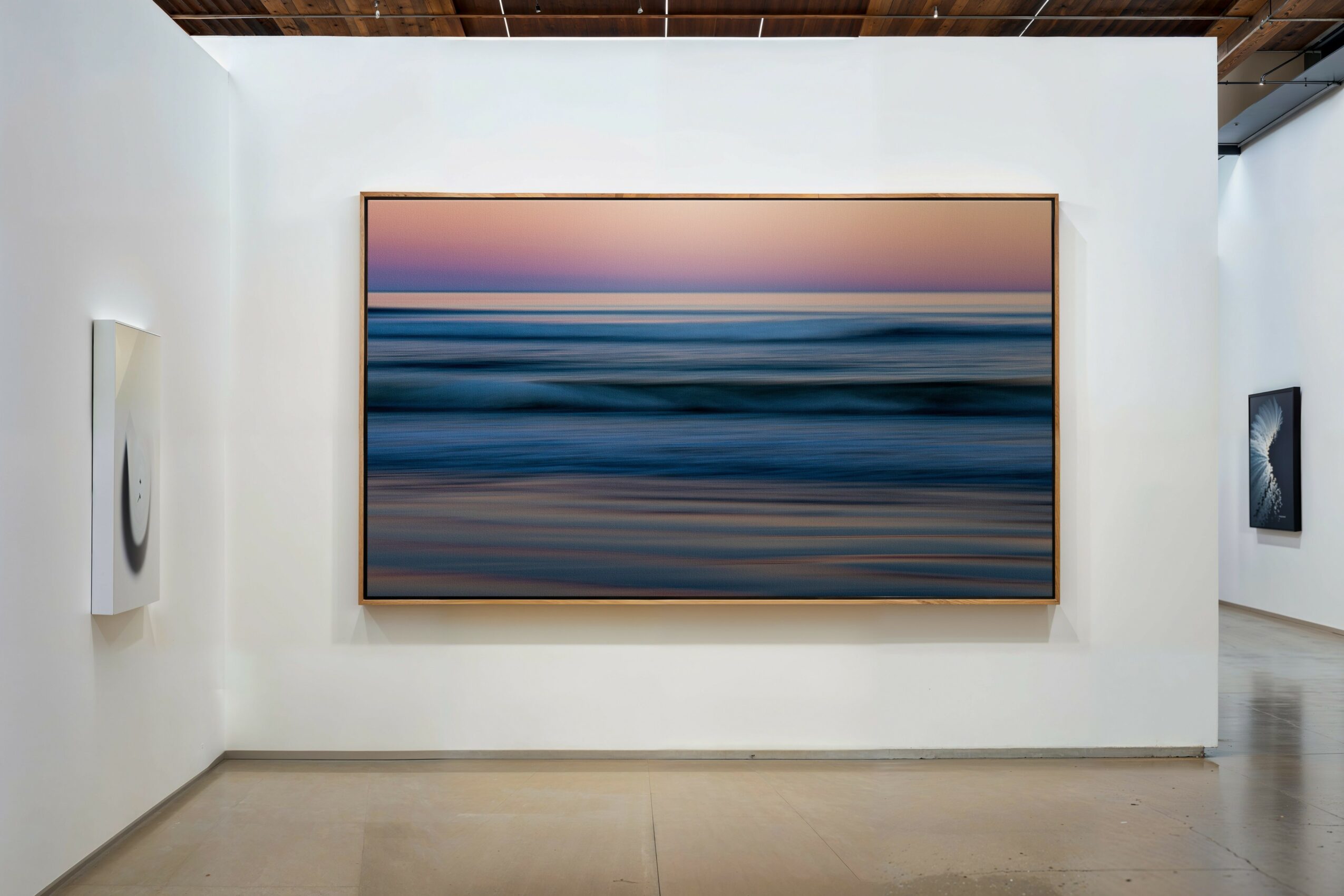Large abstract painting with horizontal bands of blue, purple, and pink on a white gallery wall.