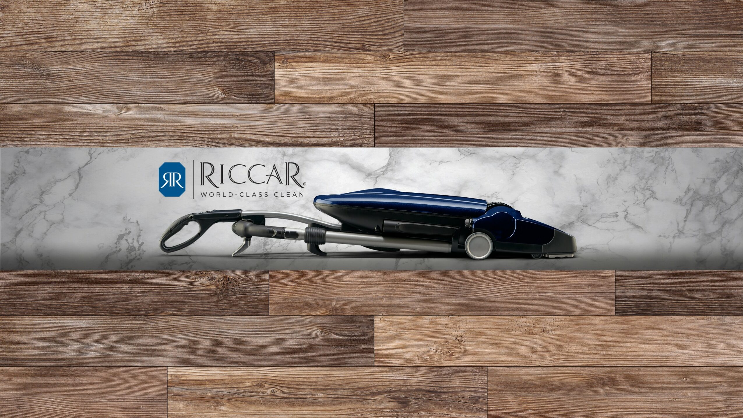 A set of hair styling tools on a marble countertop with a wooden background.