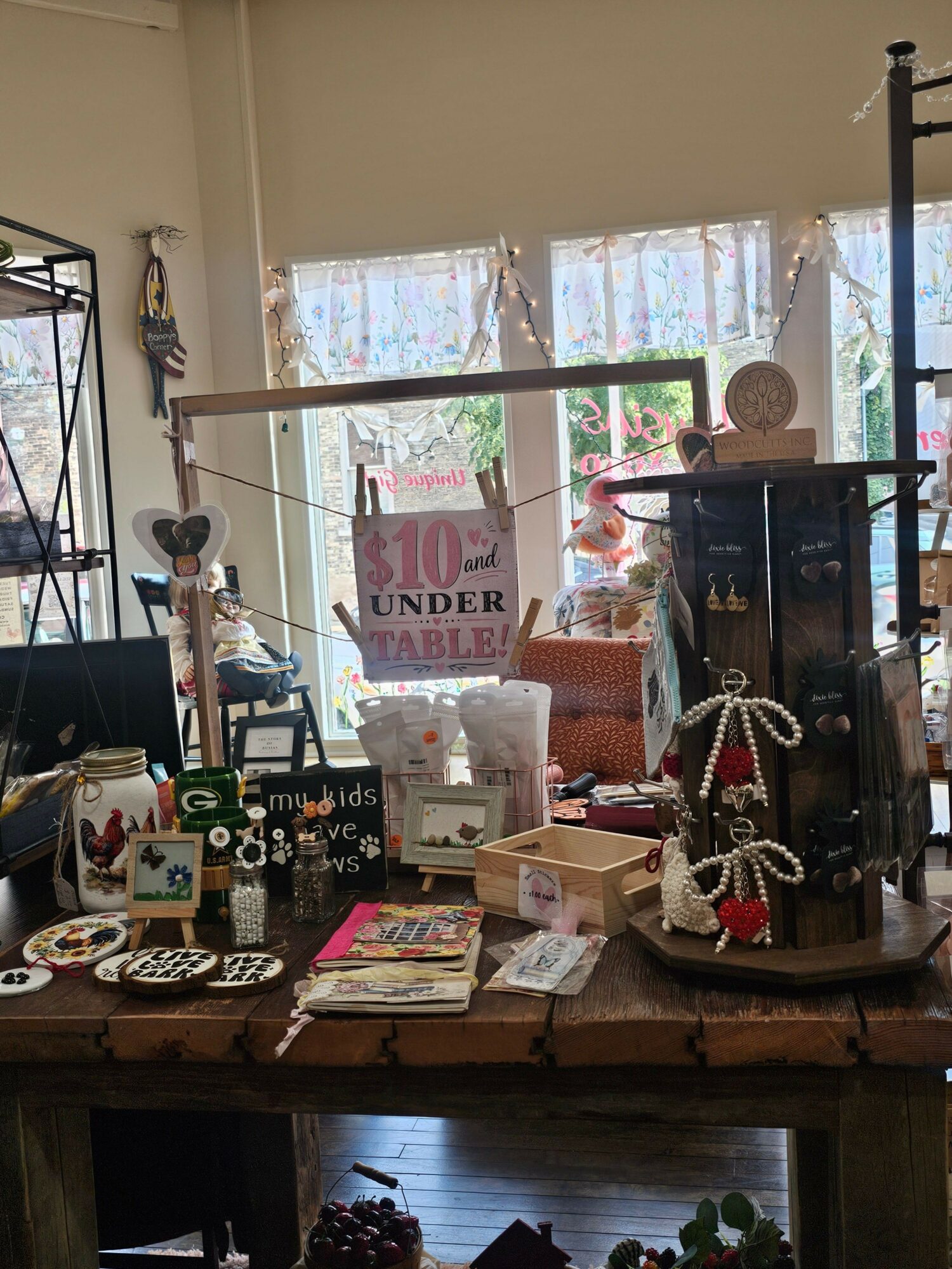 Indoor scene with various decorative items, books, and a window with curtains in the background.