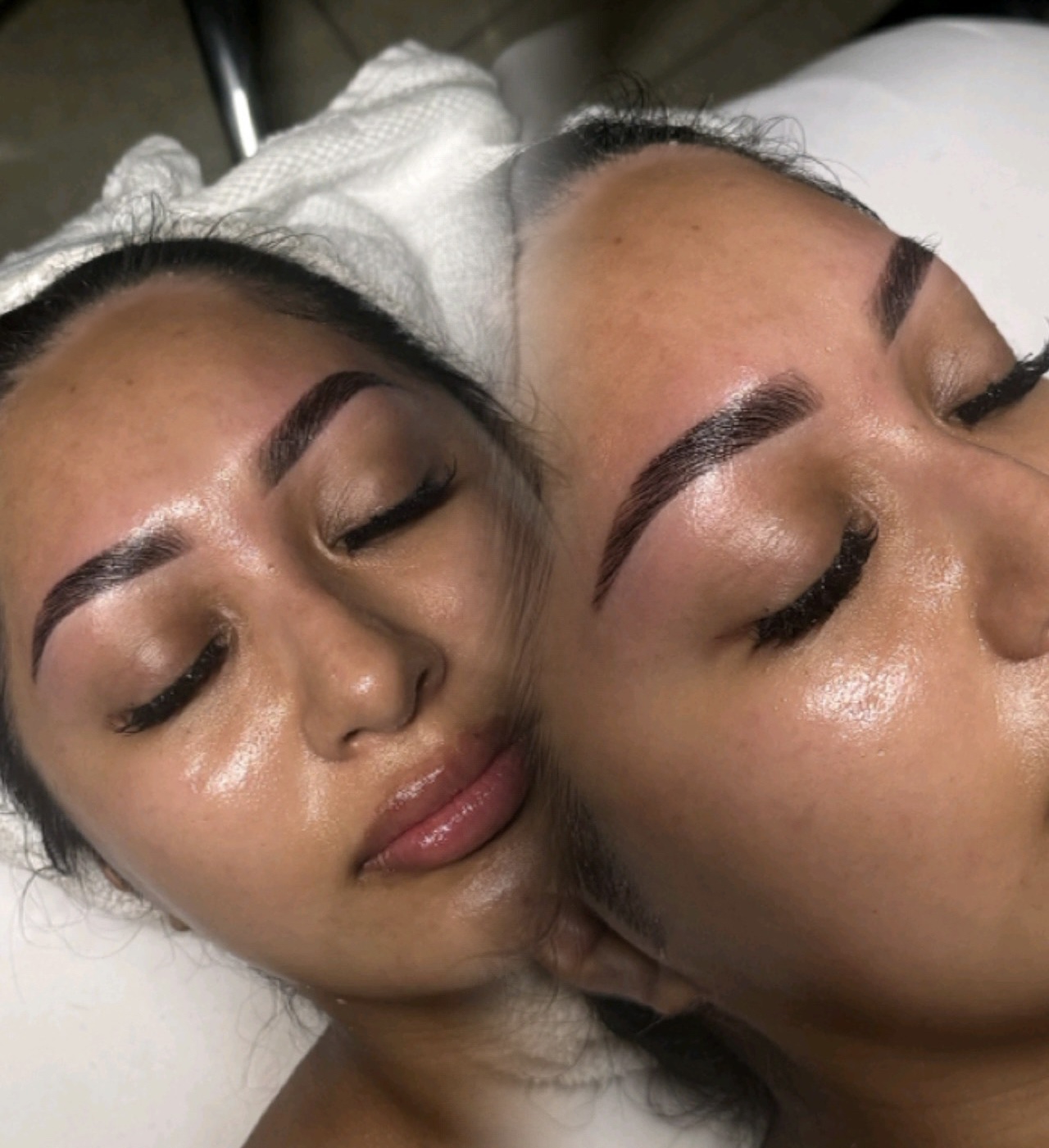 Two women with freshly done eyebrows and glowing skin, lying close together with eyes closed, in a beauty treatment setting.
