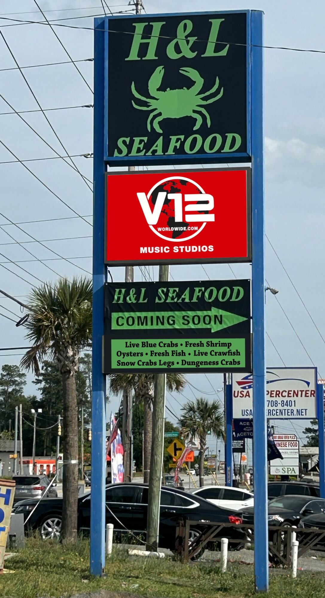 Sign for H&L Seafood with a crab logo, V12 Music Studios, and a coming soon message, with trees and cars in background.