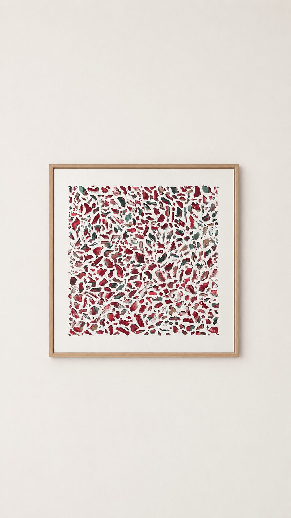Framed abstract artwork with red, green, and white shapes on a white wall.