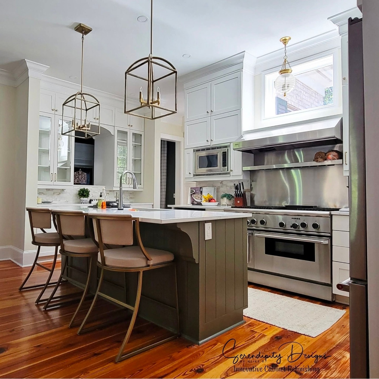 Modern kitchen with white cabinets, stainless steel appliances, and a central island with three chairs, pendant lights, and hardwood floors.