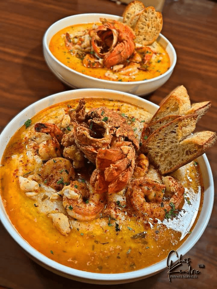 Two bowls of seafood chowder with bread slices on top, served on a wooden table.