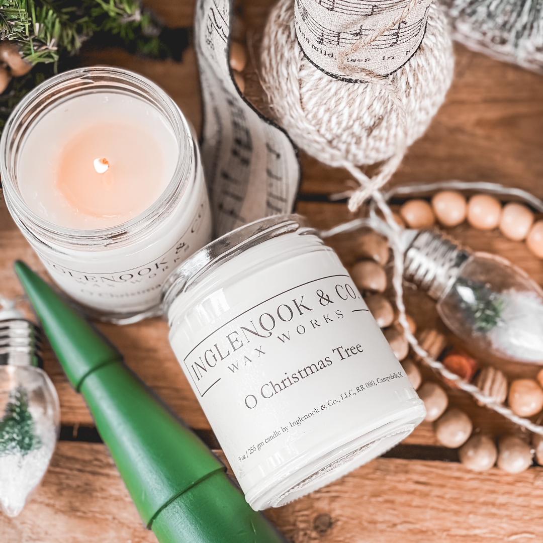 Christmas-themed candles, a green pen, and decorative items on a wooden surface.