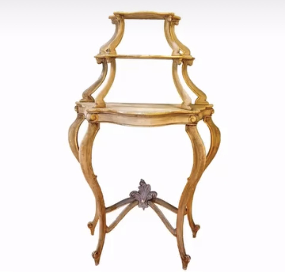 Ornate wooden three-tiered stand with curved legs and decorative details, against a plain background.