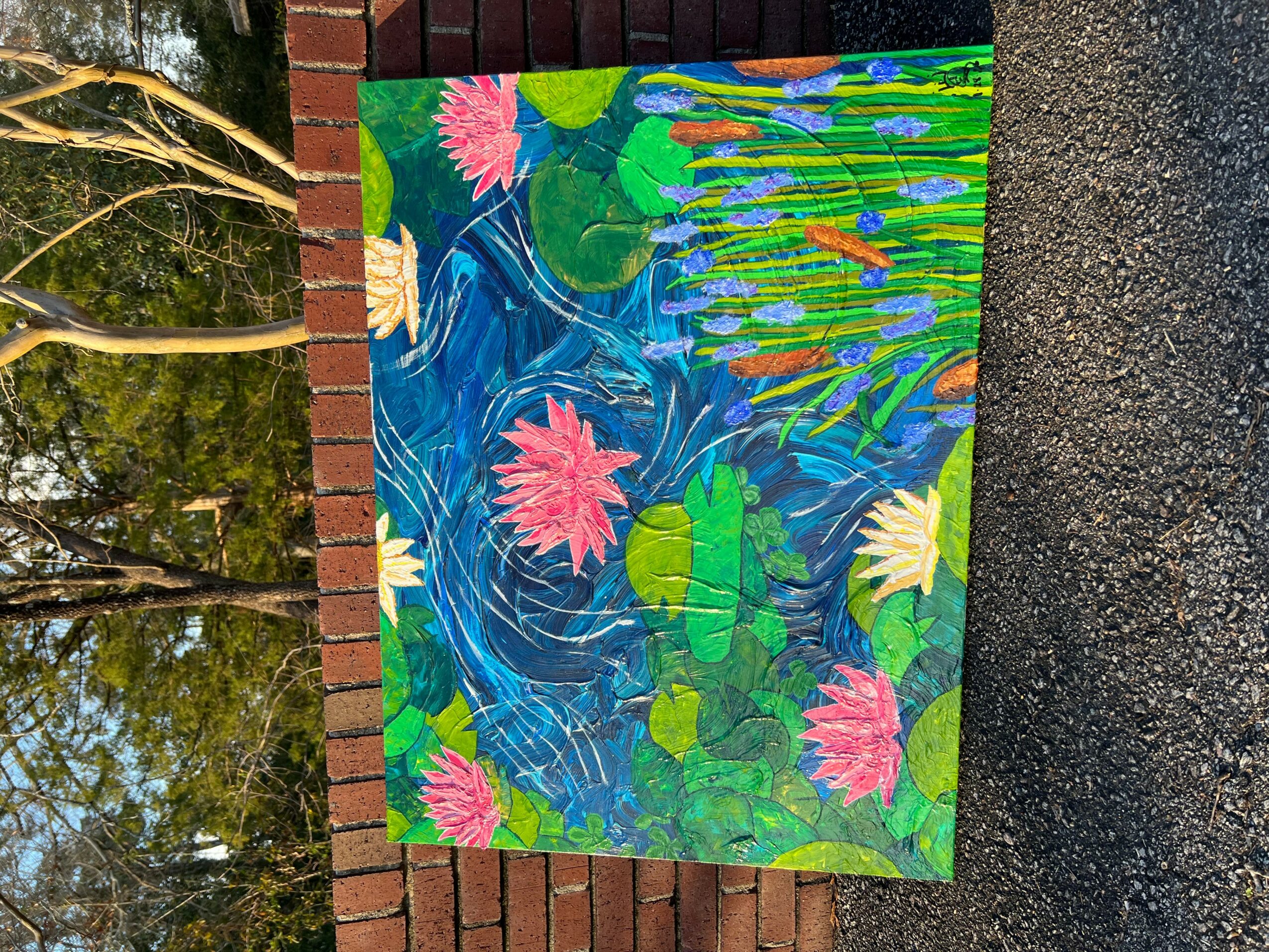 Colorful painting of water lilies and pond scene with pink, white, and green plants, on a brick wall background.