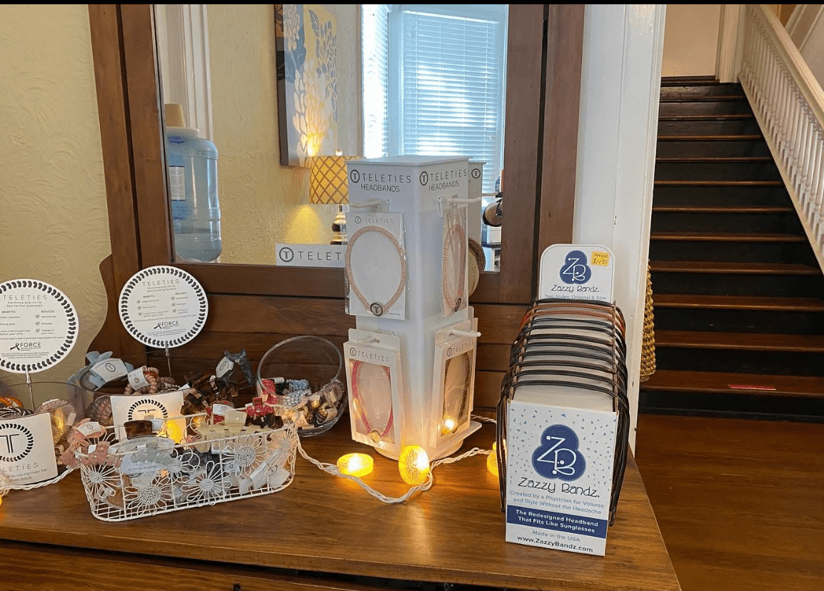 Display table with various items, a mirror, and a staircase in the background, in a well-lit room.